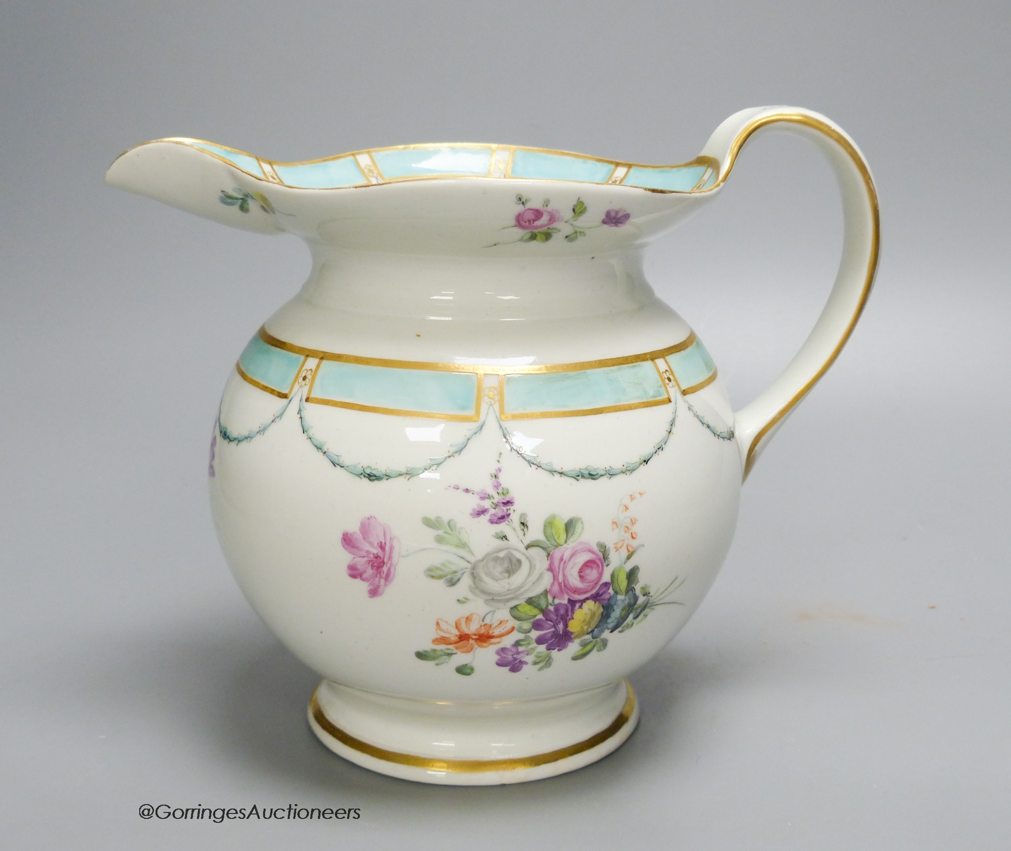 A Chelsea Derby jug of most unusual shape painted with flowers and a turquoise border, 18cm high